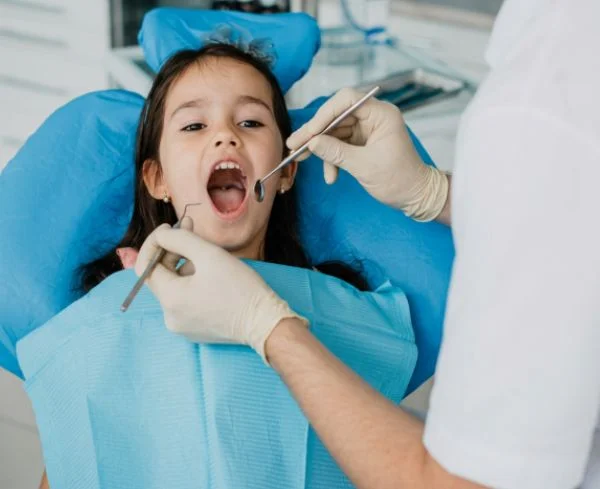 Niña mostrando un diente de leche caído tras un traumatismo dental en la clínica Multiestetik